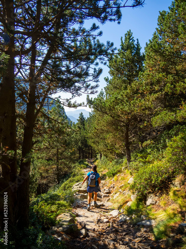 Woman summer hiking with backpack and trekking clothes in Vall de Nuria, Catalonia Pyrenees. Day trek outdoor enjoying nature and adventure. Mountain climbing active and healthy lifestyle.