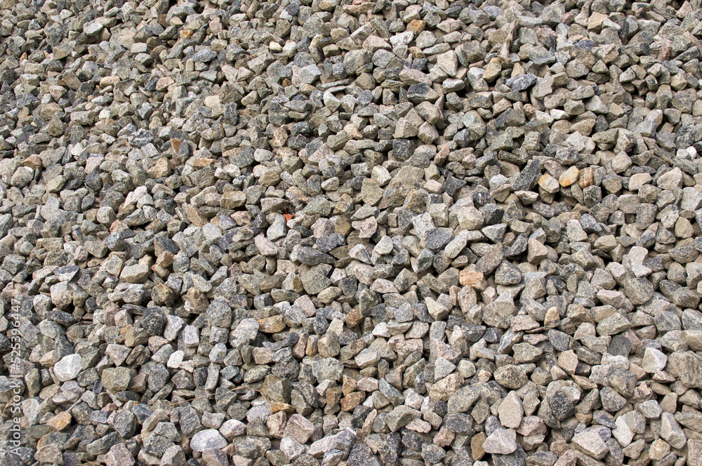 A large pile of small granite stones fills the image, outdoors in the morning. A large pile of small granite stones fills the image, outdoors in the morning.