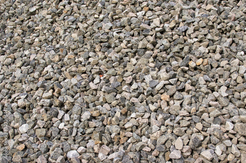 A large pile of small granite stones fills the image, outdoors in the morning.