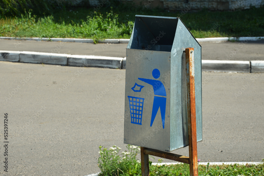 metal trash can on the street. a park in the city. background for the design. metal trash can on the street. a park in the city. background for the design.