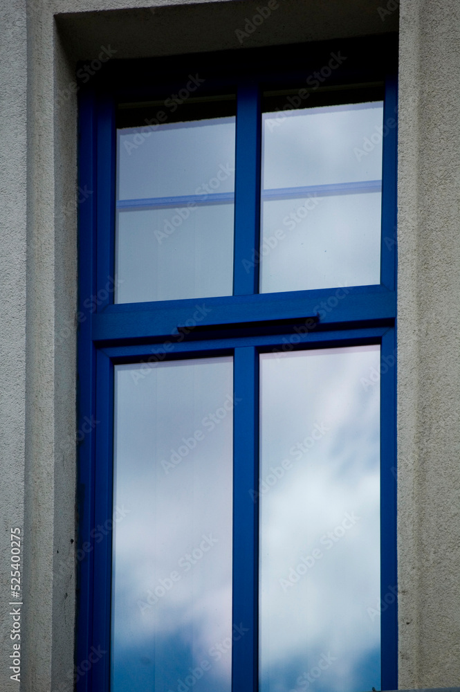 Fototapeta premium Single blue window with clouds reflection.