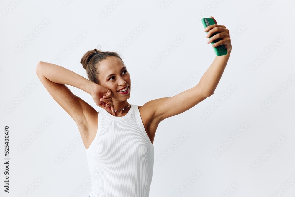 Young woman chatting on video call via phone and smiling at home on white background Young woman chatting on video call via phone and smiling at home on white background