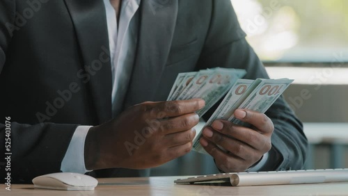 Unknown rich wealthy african businessman investor entrepreneur bookkeeper cashier banker counting money earnings salary hundred dollars banknotes winning lottery monetary prize getting deposit in bank photo