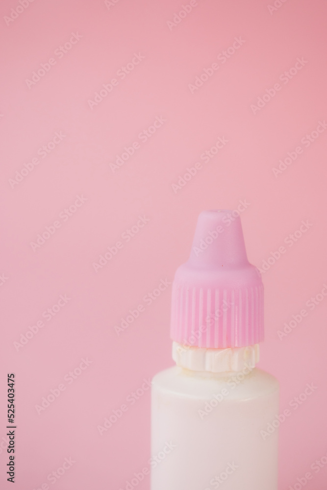 Little white bottle with dropper on pink background Little white bottle with dropper on pink background