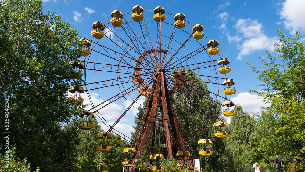 Ferris wheel in the ghost city of Pripyat after explosion of the fourth reactor Chernobyl nuclear power plant. Exclusion radioactive zone on a sunny summer day, Ukraine. Radiation, catastrophe Ferris wheel in the ghost city of Pripyat after explosion of the fourth reactor Chernobyl nuclear power plant. Exclusion radioactive zone on a sunny summer day, Ukraine. Radiation, catastrophe