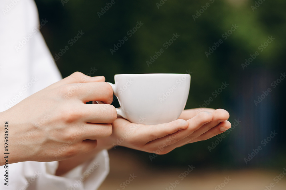 A guy in an embroidered shirt holds a cup of coffee in his hands.Coffee love concept. A guy in an embroidered shirt holds a cup of coffee in his hands.Coffee love concept.
