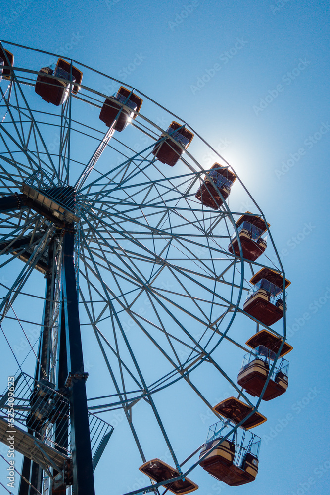 vue en contre plongée d'une grande roue à la fête foraine. Un parc d'attraction.