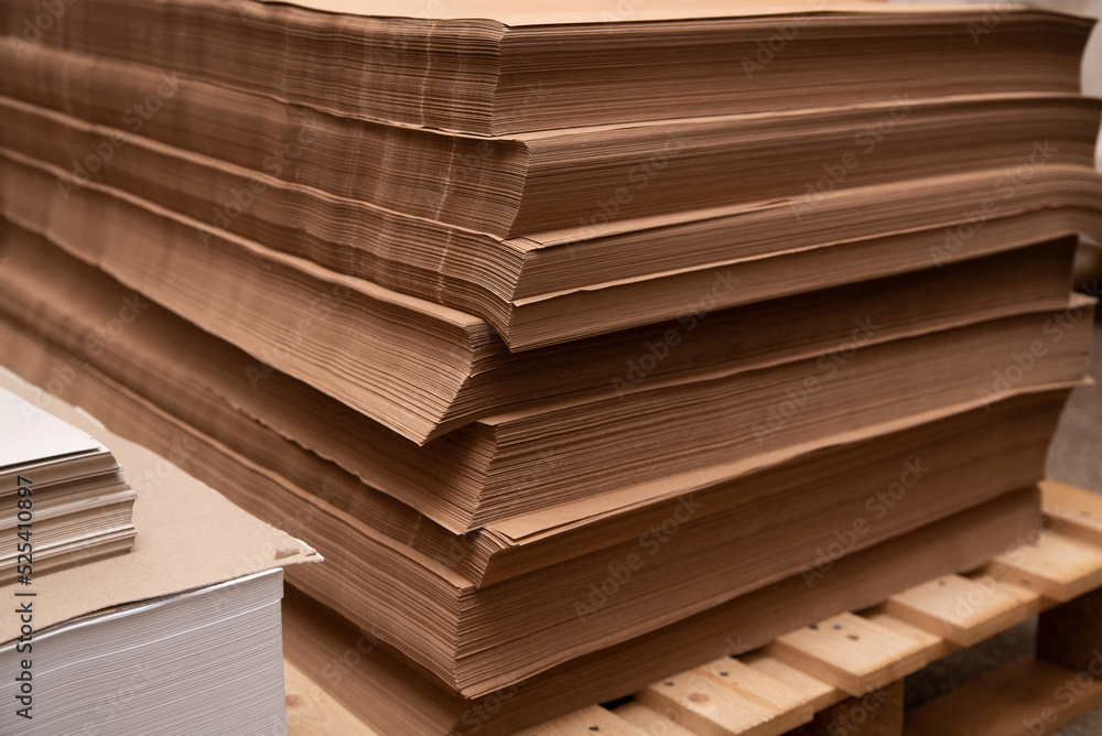 Lots of kraft paper lying on top of each other on wooden pallets at a printing plant, craft paper in large sheets for printing on it or for packaging Lots of kraft paper lying on top of each other on wooden pallets at a printing plant, craft paper in large sheets for printing on it or for packaging