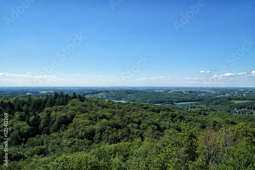 Kashubia landscape aerial view. View on Ostrzyckie Lake from observation tower located at the top of the Wiezyca hill on the in summer. Hills covered green forests with lakes. Kashubia, Poland.