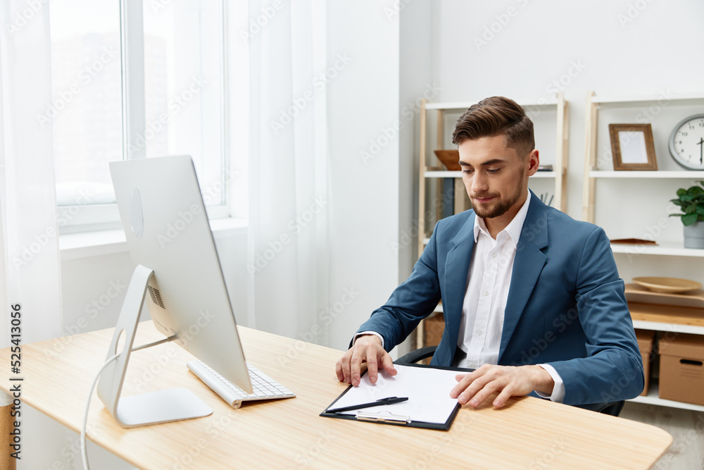 a man in a suit computer desktop work self-confidence paper folder executive a man in a suit computer desktop work self-confidence paper folder executive
