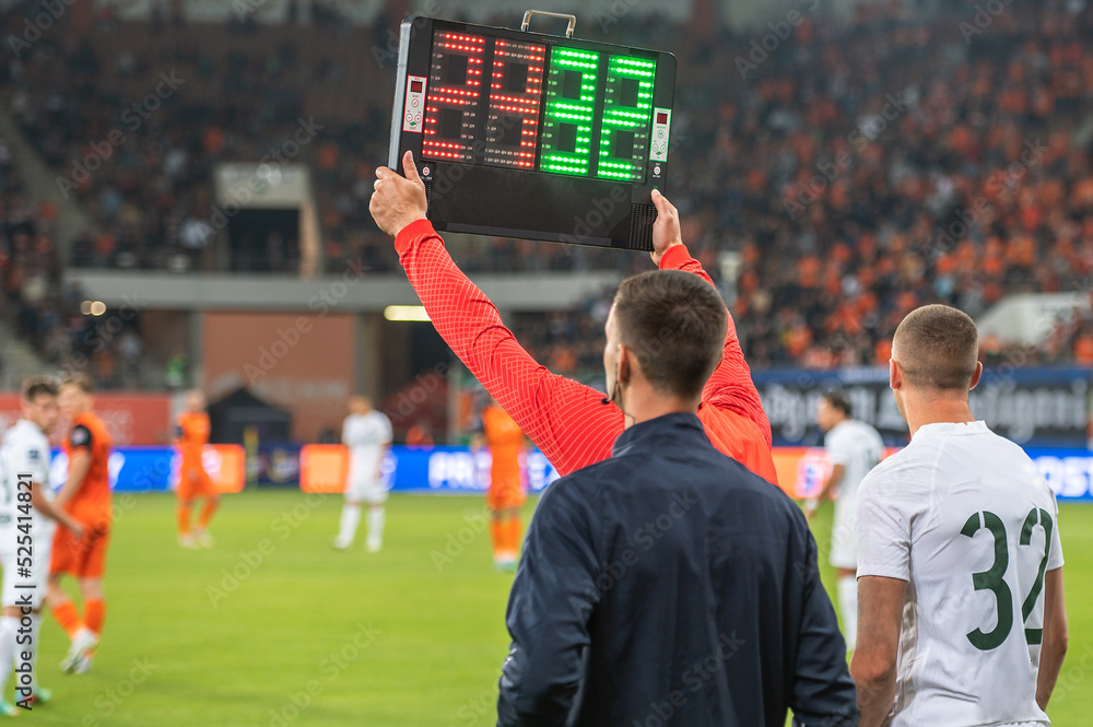 Man shows players substitution during soccer match.