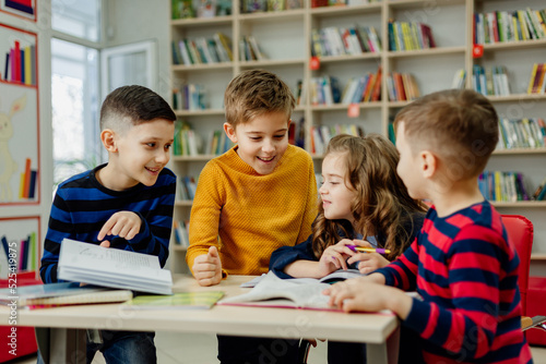 school children in the library reading books, doing homework, prepare a school project for lessons
