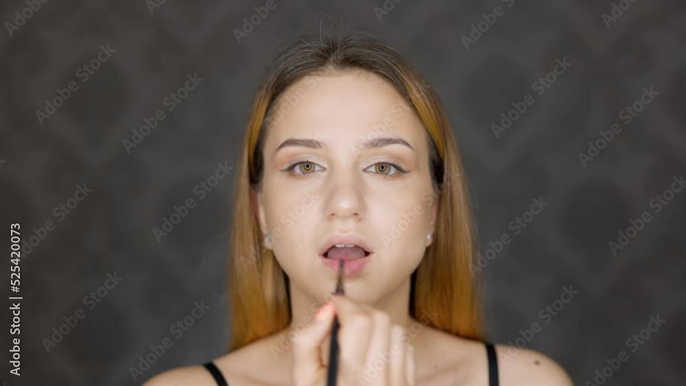 Beauty blogger girl does her make up using big ring light at home. Uses brush on the lips. Beauty blogger girl does her make up using big ring light at home. Uses brush on the lips.