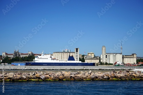 Großes Schiff im Hafen Haydarpasa vor blauem Himmel im Sonnenschein mit dem Fernsehturm Kücük Camlica im Hintergrund im Stadtteil Kadiköy in Istanbul am Bosporus in der Türkei photo