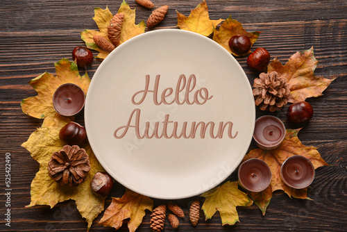 Autumn table setting with leaves and candles on wooden background