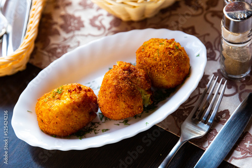 National dish of Belarus - deep-fried pyzy (potato dumplings) with mushroom stuffing garnished with greens..