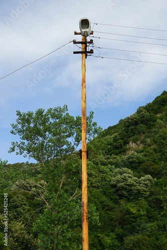 Alter Strommast aus Holz mit Straßenbeleuchtung in grüner Landschaft im Sommer bei Sonnenschein in Güzelcehisar bei Inkumu am Schwarzen Meer in der Provinz Bartin an der Schwarzmeerküste in der Türkei photo