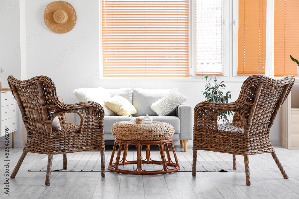 Fototapeta premium Interior of cozy living room with rattan armchairs and table