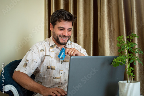 Hombre contento y conforme después de realizar una compra on-line con su computadora photo