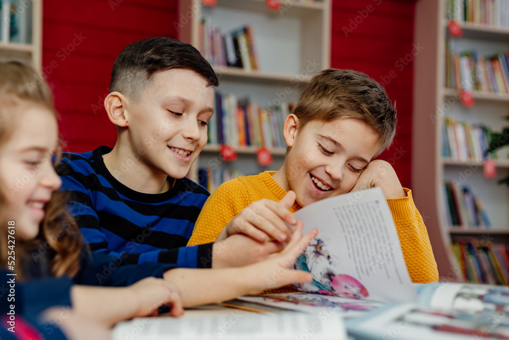 school children in the library reading books, doing homework, prepare a school project for lessons school children in the library reading books, doing homework, prepare a school project for lessons