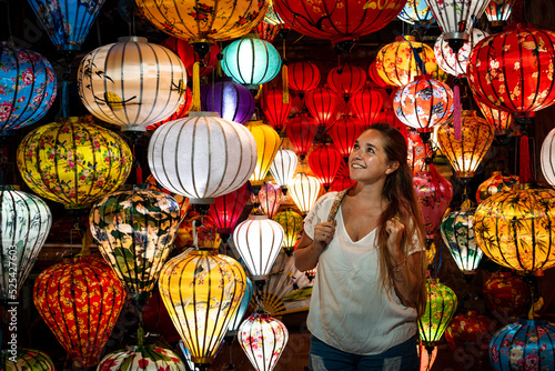 Mujer viajera disfrutando de lámparas coloridas del mercado nocturno de la ciudad de Hoi An, en Vietnam