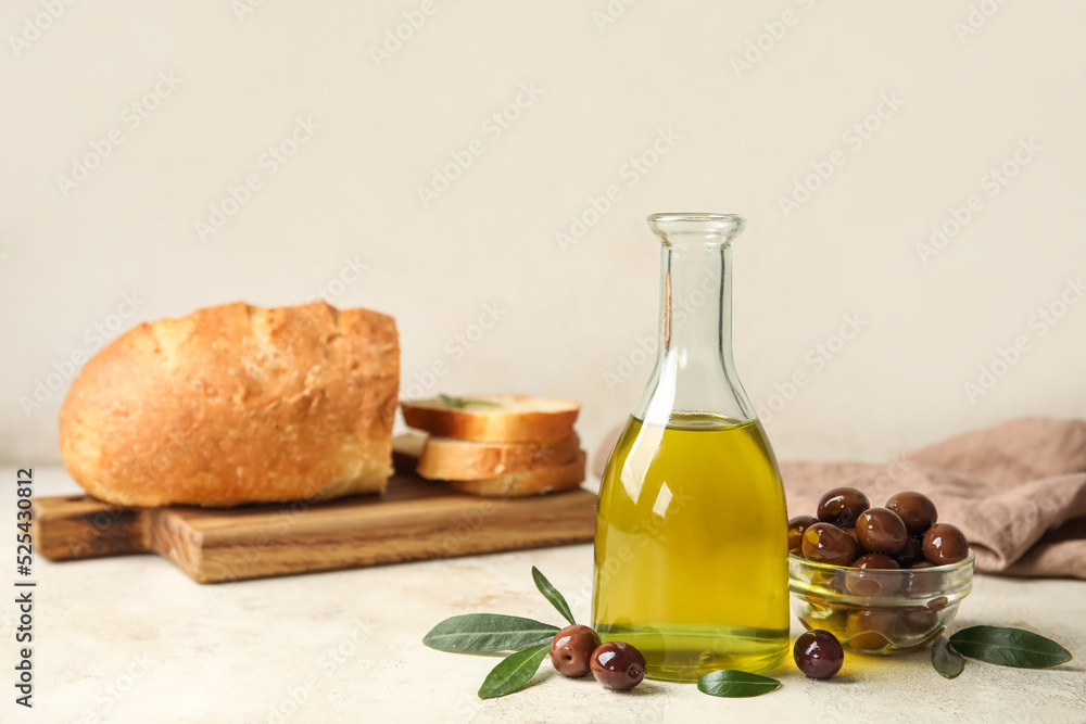 Bottle of fresh oil and bowl with olives on light background Bottle of fresh oil and bowl with olives on light background