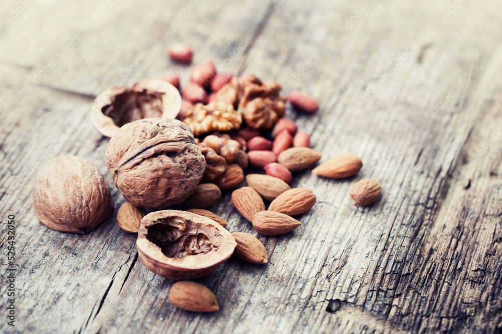 various types of nuts closeup over wooden background 