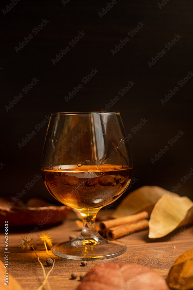 Rum, international rum day in autumn time, with dry leaves on wooden table Rum, international rum day in autumn time, with dry leaves on wooden table