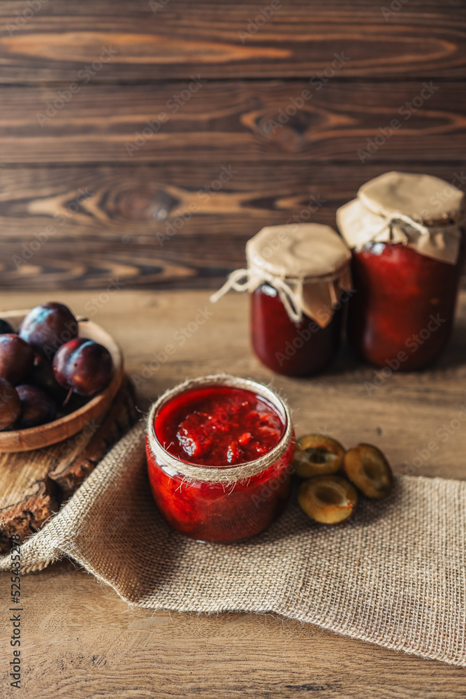 Glass jar with delicious homemade plum jam on table Glass jar with delicious homemade plum jam on table
