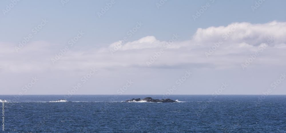 Rugged Rocks on a rocky shore on the West Coast of Pacific Ocean. Summer Morning Sky. Ucluelet, Vancouver Island, British Columbia, Canada. Nature Background Rugged Rocks on a rocky shore on the West Coast of Pacific Ocean. Summer Morning Sky. Ucluelet, Vancouver Island, British Columbia, Canada. Nature Background