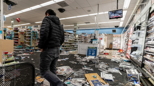 Photo man inspecting store after been looter