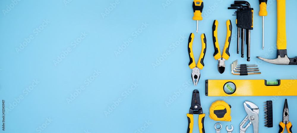 different type of yellow and black hand tools flat lay isolated baby blue background with copy space 