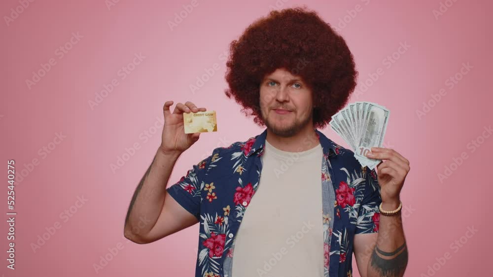 Happy tourist man showing plastic credit bank card advertising transferring money cashless, purchases online shopping, sale discount, internet order delivery purchase. Young guy boy on pink background Happy tourist man showing plastic credit bank card advertising transferring money cashless, purchases online shopping, sale discount, internet order delivery purchase. Young guy boy on pink background