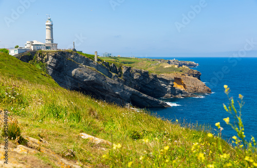 Scenic view of rocky Atlantic coast of cape Mayor with lighthouse in sunny summer day, Santander, Spain..