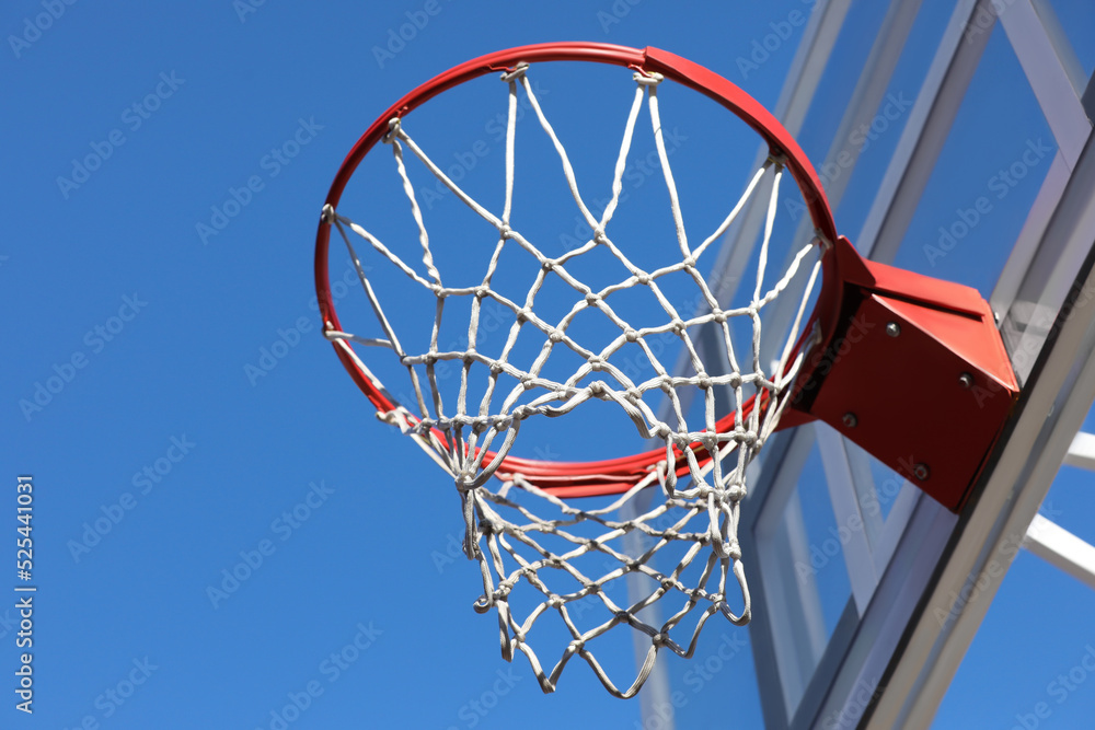 Basketball hoop with net outdoors on sunny day, low angle view Basketball hoop with net outdoors on sunny day, low angle view