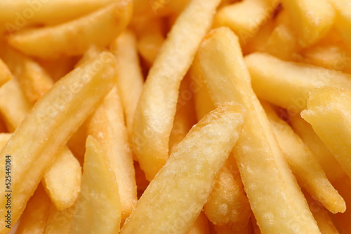 Many delicious French fry pieces as background, closeup