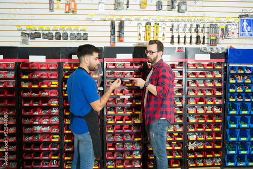 Fotografie Male hardware worker helping a customer to buy new tools