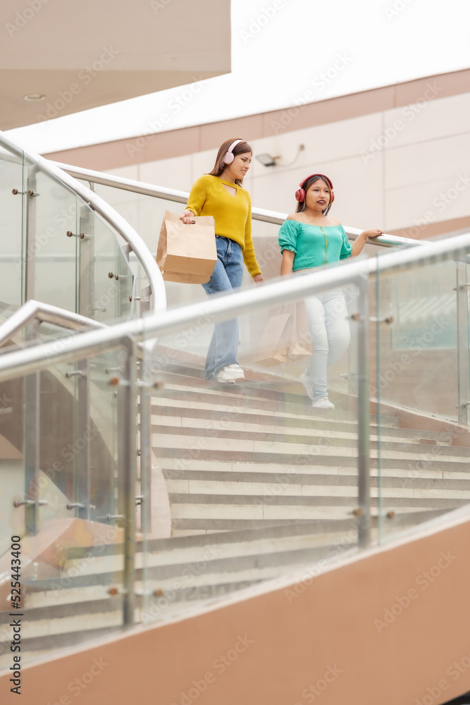 Two women with shopping bags in a mall Two women with shopping bags in a mall