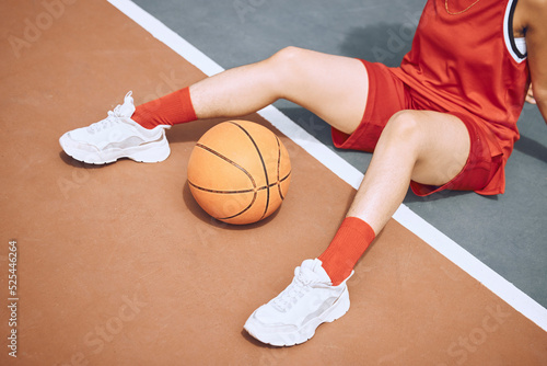 Fitness, sports and woman on basketball court floor for a break after playing a game alone in the summer. Fashion, cool and healthy athlete on the ground after training, wellness and cardio exercise