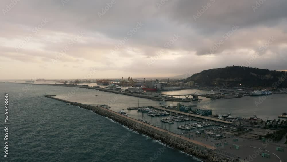 Aerial view around the Marina Vela Barcelona harbor, cloudy sunrise in Spain - circling, drone shot Aerial view around the Marina Vela Barcelona harbor, cloudy sunrise in Spain - circling, drone shot