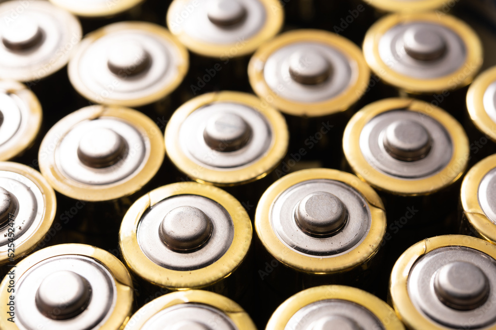 Closeup of positive ends of discharged batteries AA sizes, selective focus. Used alkaline battery. Hazardous garbage concept Closeup of positive ends of discharged batteries AA sizes, selective focus. Used alkaline battery. Hazardous garbage concept