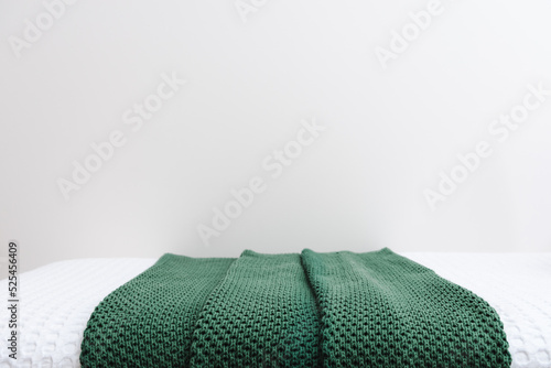 Green blanket laid on top of bed