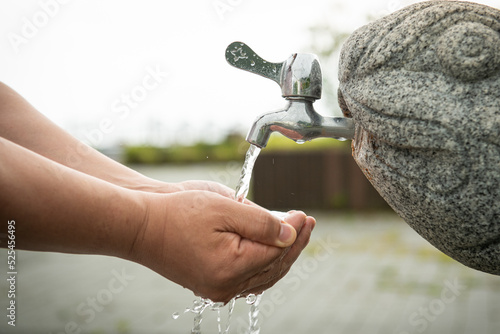 receiving water from the faucet by hand.