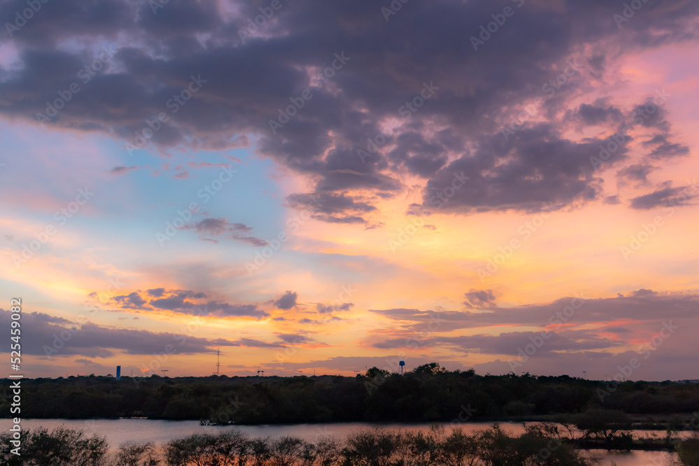 Dramatic pink and purple sunset lake reflection on Woodlawn Lake San Antonio Texas