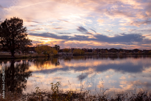 Dramatic pink and purple sunset clouds reflection on Woodlawn Lake San Antonio Texas