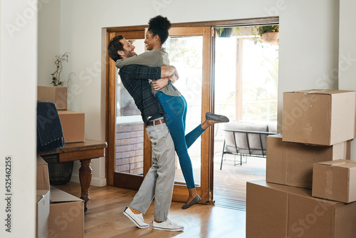 Fotografie Happy couple celebrating a new home with a husband lifting his wife in excited, romantic and in love celebration together