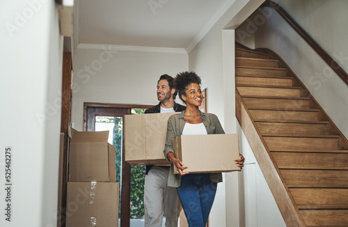 Obraz na plátne Excited, happy and young couple moving into a new home together while carrying and packing household boxes