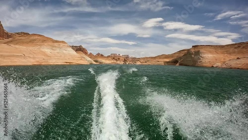 Wake of a jet ski boat riding through red canyons of Lake Powell in Utah photo