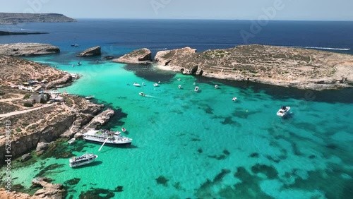 Drone footage flying over boats, people, and jetskis at the incredible blue lagoon on Comino Island in Malta. photo