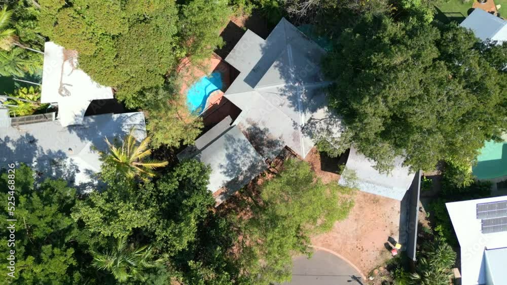top-down drone shot of houses with pools at the end of a quiet street. Houses amongst green tress in suburban area top-down drone shot of houses with pools at the end of a quiet street. Houses amongst green tress in suburban area